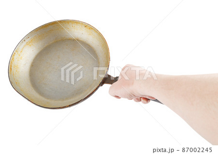 bare caucasian hand holding empty old aluminium frying pan bare caucasian hand holding empty old aluminium frying pan 87002245