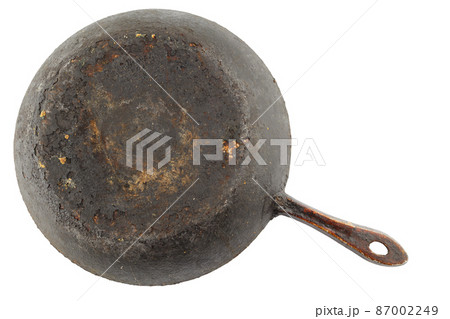 old stained rusty cast iron pan with burnt fat isolated on white bottom up in flat lay perspective 87002249