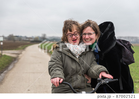 Hakendover, Flanders / Belgium -Portrait of a happy white woman with Down Syndrome and a normal woman holding each other 87002521
