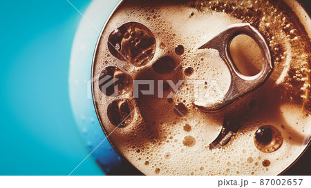 Frothing beer, cola or energy drink from open can, top view, copy space Frothing beer, cola or energy drink from open can, top view, copy space 87002657