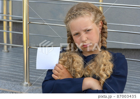 girl holding paper Concept School girl in a uniform. pupil, learner, scholar. schoolgirl girl holding paper Concept School girl in a uniform. pupil, learner, scholar. schoolgirl 87003435