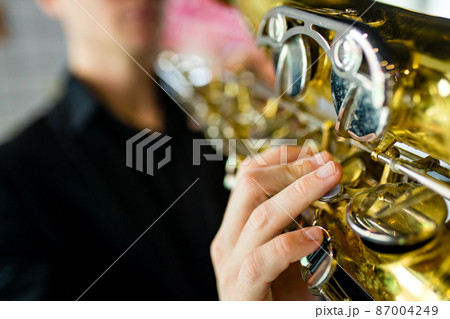 saxophone in hands close-up man in black outfit 87004249
