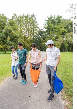 ウオーキングしながら公園を綺麗にする若者たち 87005495