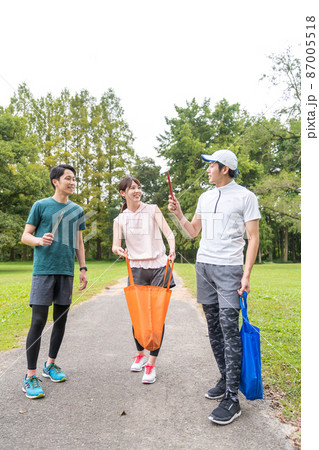 ウオーキングしながら公園を綺麗にする若者たち 87005518