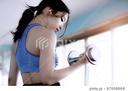スポーツジムで筋トレする若い女性 スポーツジムで筋トレする若い女性 87008668