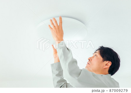 照明器具をチェックする作業着の男性（チェック） 87009279
