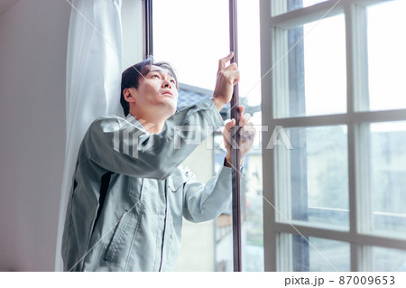 窓冊子を確認する作業着の男性 87009653