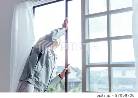 窓冊子を確認する作業着の男性 87009706