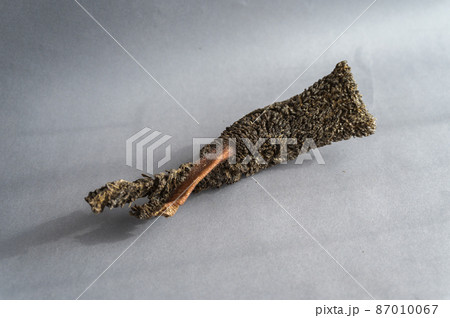 Pet treats against a gray background. Dried beef tripe. Pieces of natural, wholesome chewable dog treats. Pet treats against a gray background. Dried beef tripe. Pieces of natural, wholesome chewable dog treats. 87010067