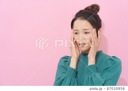 頭をおさえる女性 カラー背景 頭をおさえる女性 カラー背景 87010956