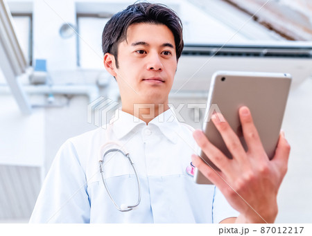 老人ホーム　タブレットパソコンを持った男性ケアスタッフ 87012217