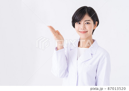 白バックの白衣の若い女性 87013520