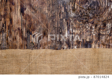 Fabric sackcloth on dark wooden background. 87014824