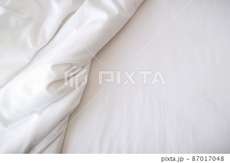 White bedding sheets on bed in bedroom. Morning lifestyle concept. White bedding sheets on bed in bedroom. Morning lifestyle concept. 87017048