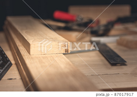 A man makes wood products with the help of special tools. Portrait of a young carpenter at work. Employment in the woodworking industry A man makes wood products with the help of special tools. Portrait of a young carpenter at work. Employment in the woodworking industry 87017917