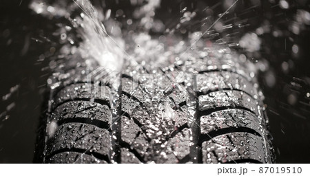 Water splashing on new car tyre closeup Water splashing on new car tyre closeup 87019510