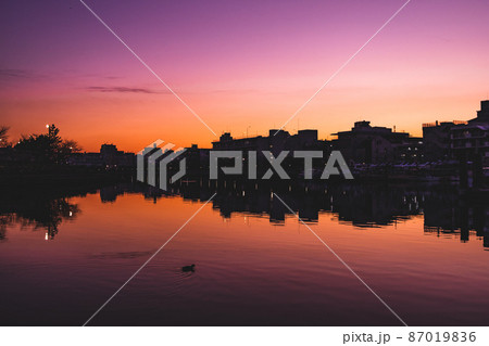 日没後の街のシルエットと運河に反射する街 日没後の街のシルエットと運河に反射する街 87019836