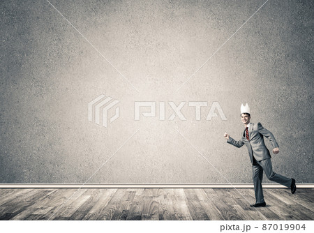 King businessman in elegant suit running in empty room 87019904