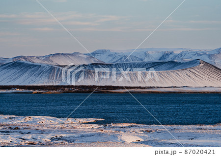 Volcano crater over the lake covered by snow 87020421