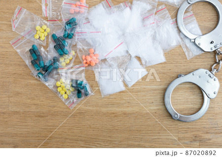 On the table lie bagged loose and toilet drugs and handcuffs. On the table lie bagged loose and toilet drugs and handcuffs. 87020892
