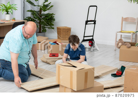 A father and son review how to assemble a new bookcase. A father and son review how to assemble a new bookcase. 87020975