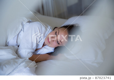 beautiful woman sleeping in white bed in the morning. beautiful woman sleeping in white bed in the morning. 87023741