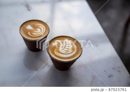 Two beautiful cups of cappuccino with latte art on table. 87023761