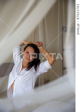 woman waking up stretching arms on the bed in the morning woman waking up stretching arms on the bed in the morning 87023763