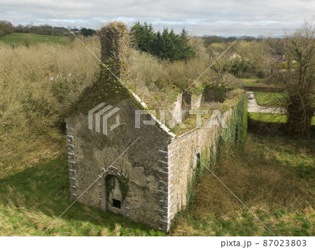 Old ruins of a small village church on the outskirts along with a cemetery 87023803