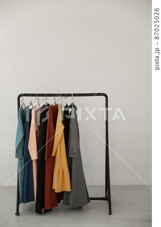 Black minimalistic rack with eco linen clothes on white background. Black minimalistic rack with eco linen clothes on white background. 87025026