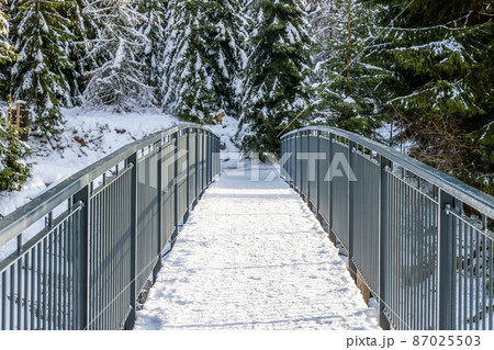 Pedestrian broder bridge over Jizera River in winter 87025503