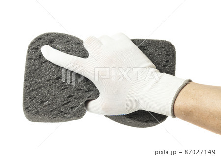 Hand in gloves holding sponge isolated on a white background 87027149