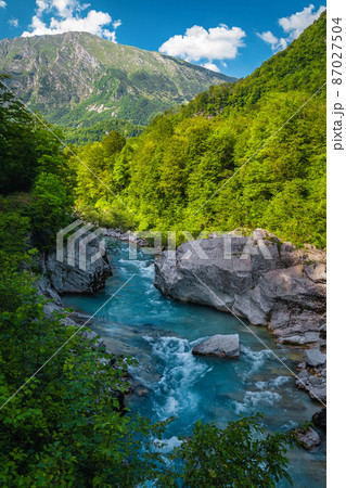 Soca river with rocky shoreline in the forest, Kobarid, Slovenia Soca river with rocky shoreline in the forest, Kobarid, Slovenia 87027504