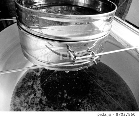 Drop of bee honey drip from hexagonal honeycombs Drop of bee honey drip from hexagonal honeycombs 87027960