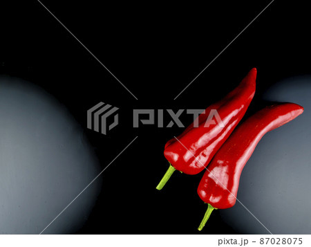Red pepper on a black background with place for text. Red pepper on a black background with place for text. 87028075