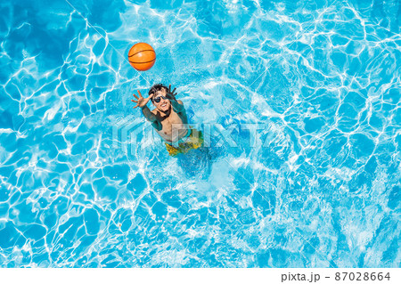 Man play in the pool with a beach ball 87028664