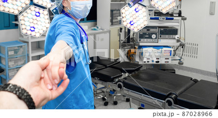 A female doctor pulls a human by the hand into the operating room. 87028966
