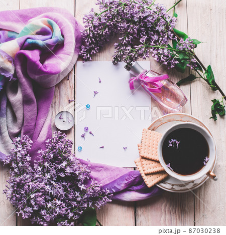Morning cup of tee, cookies, and lilac flower on wooden table from above. Beautiful breakfast. Flat lay style with copy space Morning cup of tee, cookies, and lilac flower on wooden table from above. Beautiful breakfast. Flat lay style with copy space 87030238