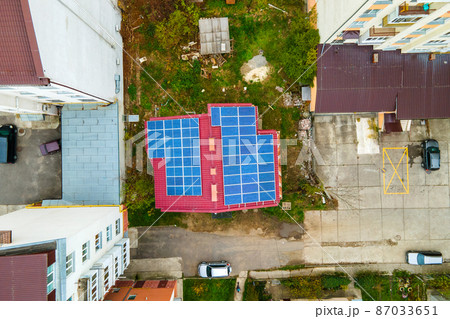 Aerial view of residential houses with rooftops covered with solar photovoltaic panels in suburban rural area Aerial view of residential houses with rooftops covered with solar photovoltaic panels in suburban rural area 87033651
