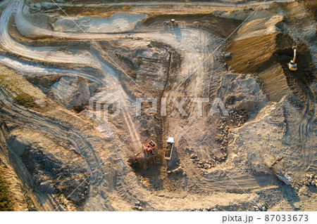 Aerial view of open pit mine of sandstone materials for construction industry with excavators and dump trucks. Heavy equipment in mining and production of useful minerals concept 87033673