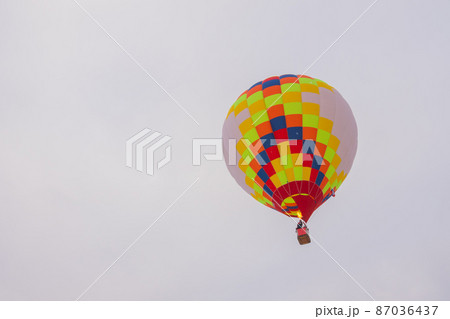 Colorful hot air balloon flying against grey sky at Winter aerostat festival Colorful hot air balloon flying against grey sky at Winter aerostat festival 87036437