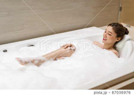 woman relaxing and takes bubble bath in bathtub with foam 87036976