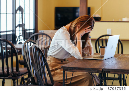 パソコンの前で頭を抱える女性 Depressed パソコンの前で頭を抱える女性 Depressed 87037356