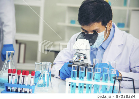 Scientist man look into Microscope research in science laboratory. Asian scientist looking equipment laboratory chemistry labs. Covid-19 coronavirus biochemistry research experiment vaccine concept Scientist man look into Microscope research in science laboratory. Asian scientist looking equipment laboratory chemistry labs. Covid-19 coronavirus biochemistry research experiment vaccine concept 87038234