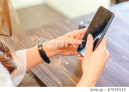 携帯電話を操作する女性　cell phone 87038523
