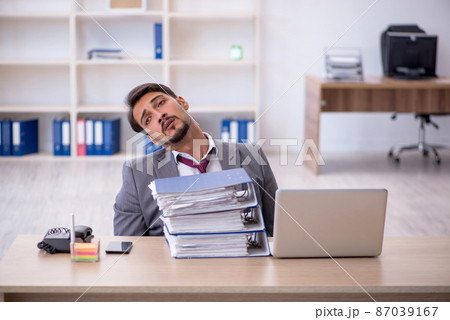 Young male employee working in the office Young male employee working in the office 87039167