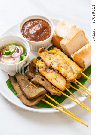 Pork Satay with your Peanut Sauce  and pickles which are cucumber slices and onions in vinegar 87039611