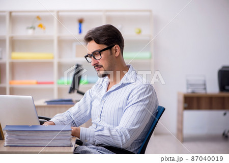 Young male employee working in the office 87040019