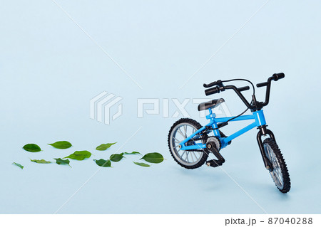World bicycle day. Bicycle emitting fresh green leaves on blue background. Sustainable and healthy concept 87040288