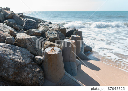 Stones on the beach by the sea. Wave in the ocean near the breakwater. High quality photo Stones on the beach by the sea. Wave in the ocean near the breakwater. High quality photo 87042823